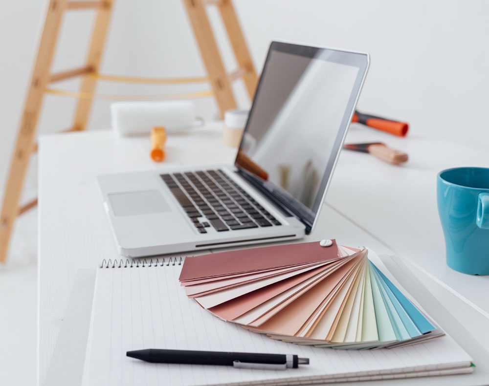 A laptop, colour swatch book, and building materials.