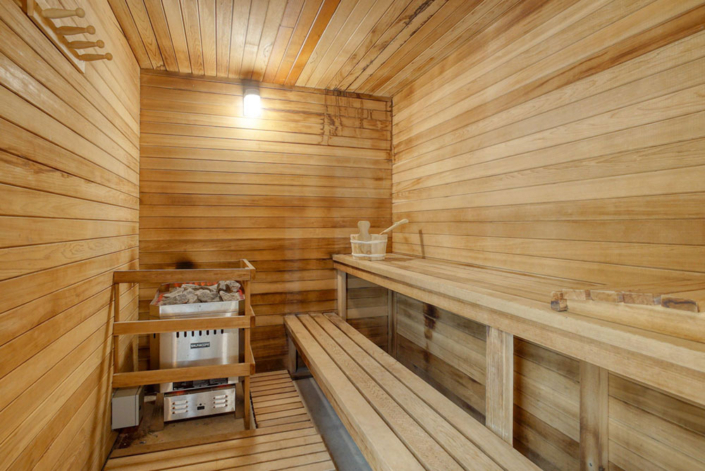 Private in-home sauna for ultimate relaxation, featuring a traditional wood-panelled interior and sauna stones.