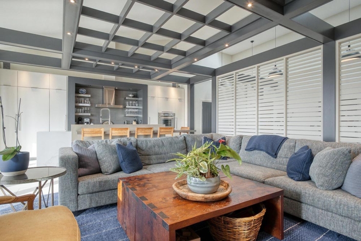 A beautiful living space with a large sectional sofa and custom ceiling.