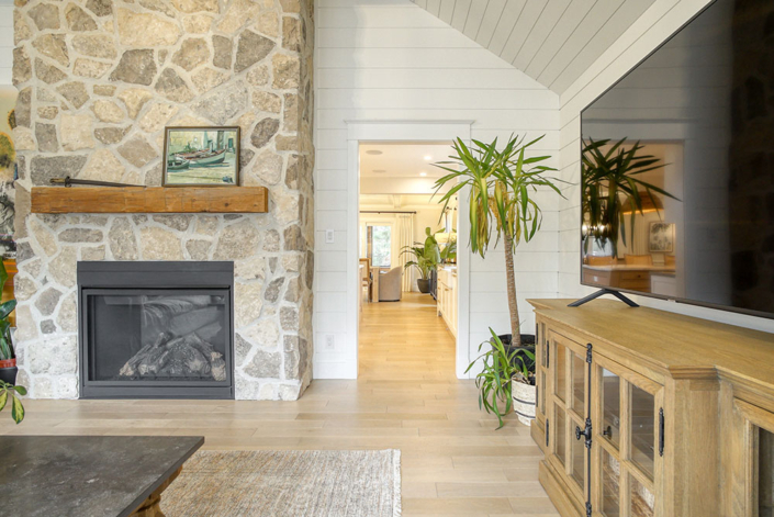 A custom living space with high ceilings and a stone fireplace by Haggerty Homes.