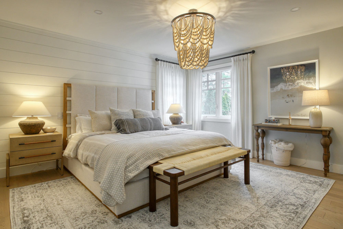 Serene primary bedroom showcasing a peaceful ambiance, with neutral tones and a large area rug.
